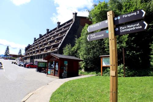 a pole with street signs in front of a building at Yomo Patagonia in Arinsal