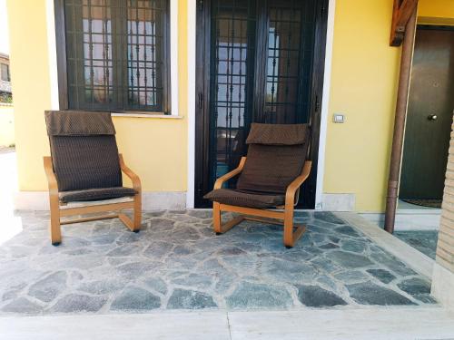 twee stoelen op de veranda van een huis bij Cottage OstiaAntica in Ostia Antica