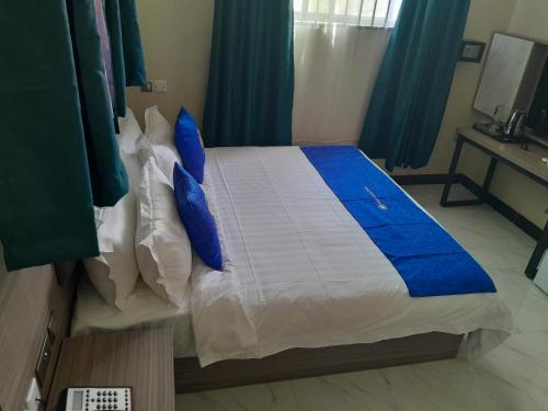 a bedroom with a large bed with blue pillows at VEGAS LUXURY HOTEL in Dar es Salaam