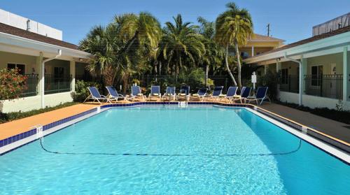 a large swimming pool with chairs and palm trees at Hotel SOL in St Pete Beach