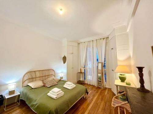a bedroom with a green bed with towels on it at The Gallery - HyperCentre Reims in Reims