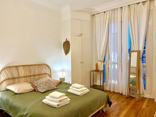 - une chambre avec un lit vert et des serviettes dans l'établissement The Gallery - HyperCentre Reims, à Reims