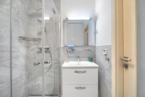 uma casa de banho com um lavatório e um chuveiro em Warta River Comfort Apartment em Poznań