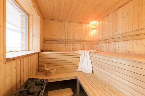 a wooden sauna with a bench in the middle at Wellnesshaus "Wind" in Fehmarn