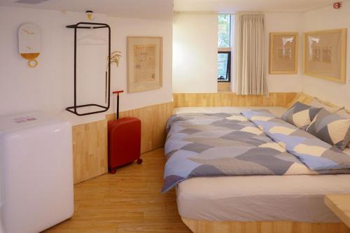 a bedroom with a large bed and a red dresser at TGS Studio Hotel in Guangzhou