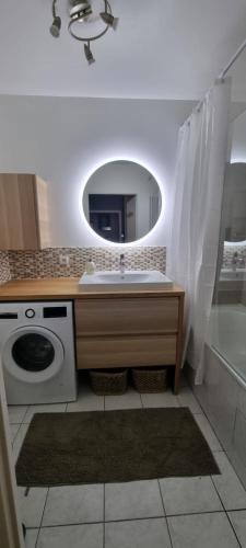 a bathroom with a sink and a washing machine at Appartement cosy près du RER in Chessy