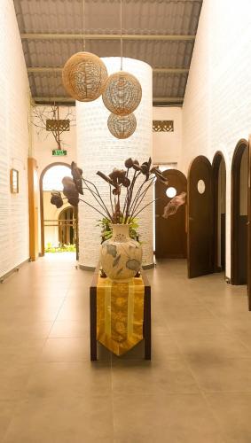 a lobby with a vase with flowers in it at GOLDEN LOTUS SPA & HOMESTAY in Ấp Thiện Phước