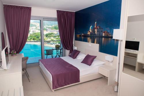 a bedroom with a bed and a large window at Hotel Ponta Nova in Budva