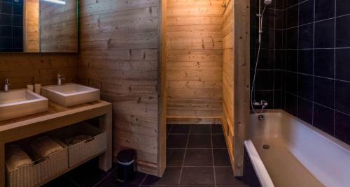 une salle de bain avec une baignoire et un lavabo et une baignoire dans l'établissement Igloo, à Morzine