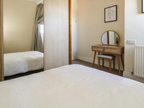 sypialnia z łóżkiem, biurkiem i lustrem w obiekcie 123 On The Sea w mieście Weymouth