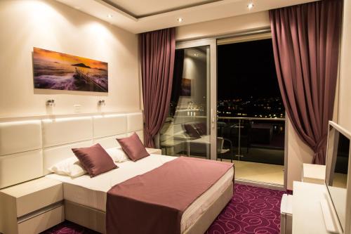 a bedroom with a bed and a large window at Hotel Ponta Nova in Budva
