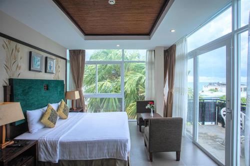 ein Schlafzimmer mit einem Bett und einem großen Fenster in der Unterkunft Seaside Resort Vung Tau in Vũng Tàu