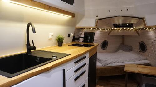 una cucina con lavandino e un letto in una roulotte. di Ausgebautes Rettungsboot GORCH POTT ad Amburgo