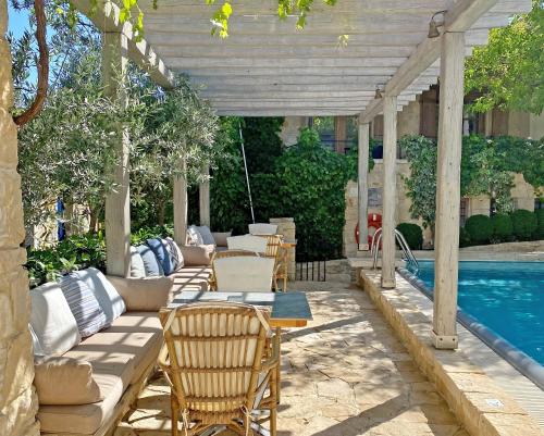 a patio with a couch and chairs next to a pool at Apokryfo Traditional Guesthouse in Lofou
