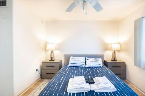 Un dormitorio con una cama azul con toallas. en Hidden Gem in Tempe 2 bed, 2 bath en Tempe