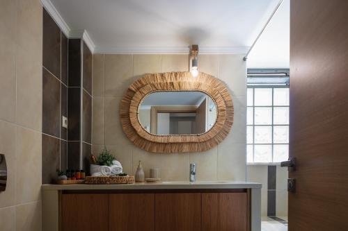 a bathroom with a sink and a mirror on the wall at JW luxury apartment in Chania