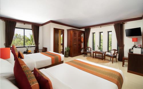 Habitación de hotel con 2 camas y escritorio en Khemara Sovannphum Hotel en Siem Reap