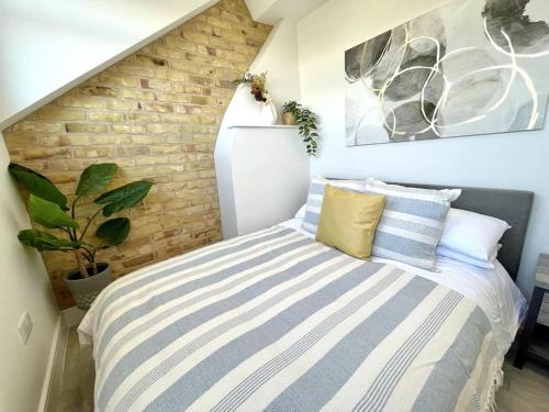 a bedroom with a bed and a brick wall at Stunning Beachside 3 Porthcawl in Porthcawl