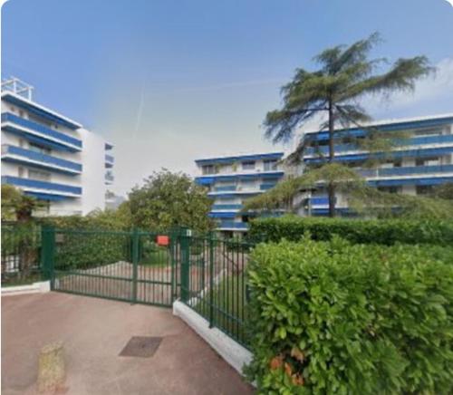 een hek voor een gebouw met een boom bij Studio Cap Martin in Roquebrune-Cap-Martin