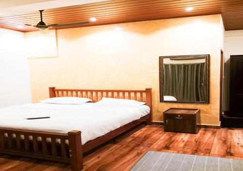 a bedroom with a bed and a mirror on the wall at Vaiga Homes - Vembanadu Lakeview Retreat in Cochin