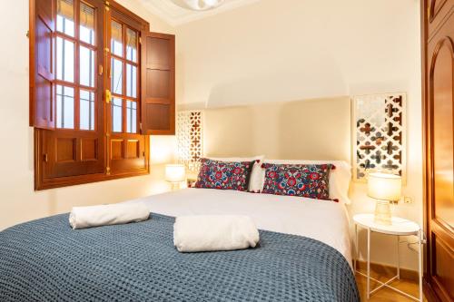 a bedroom with a large bed with two pillows at AoA Green Gardens Family House in Seville