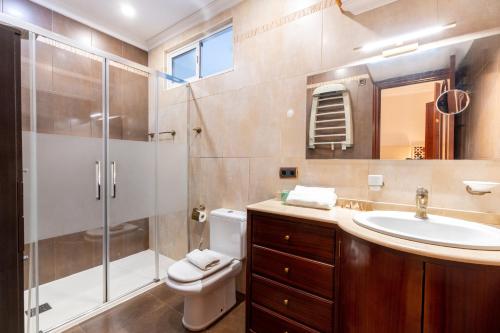 a bathroom with a shower and a toilet and a sink at AoA Green Gardens Family House in Seville