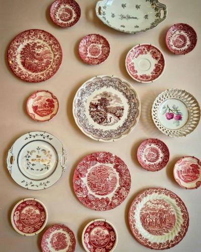 a wall full of red and white plates on a wall at La Campagne Villa Chiangmai in Chiang Mai