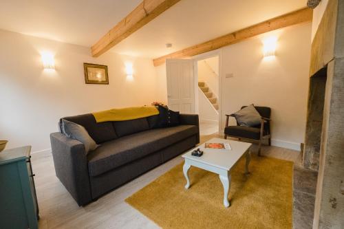 ein Wohnzimmer mit einem Sofa und einem Tisch in der Unterkunft Swan House in Huddersfield