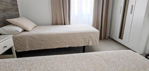 a small room with two beds and a window at Villa Magnolia in Callao Salvaje
