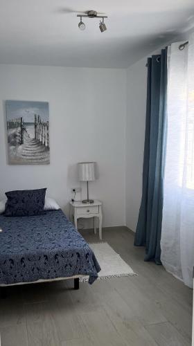 a bedroom with a bed and a table with a lamp at Villa Magnolia in Callao Salvaje