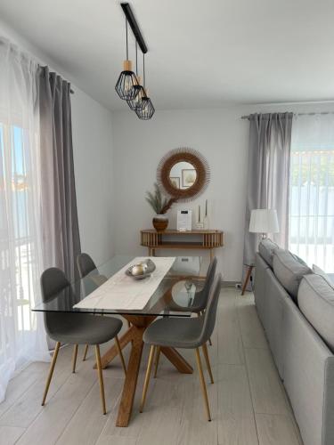 a dining room with a table and a couch at Villa Magnolia in Callao Salvaje