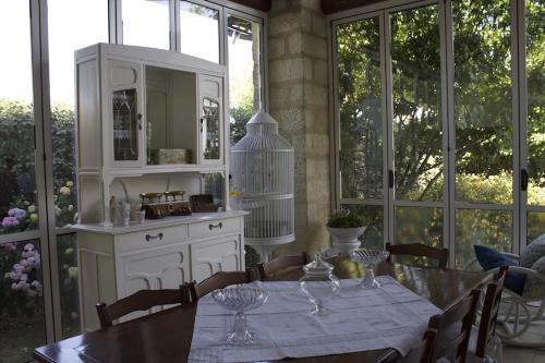 a dining room with a table and a kitchen with windows at Cascina Manu in Rosignano Monferrato