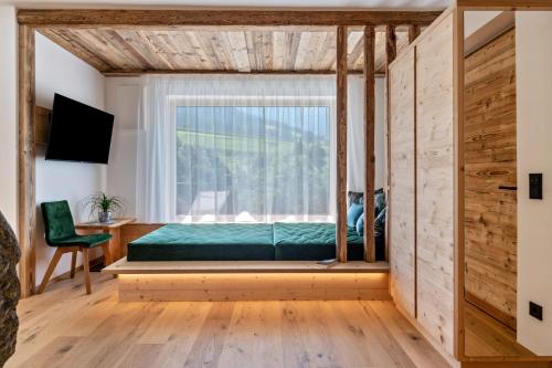 - une chambre avec un lit et une fenêtre dans l'établissement Chalet Kasch Apartment Glück, à Vols am Schlern