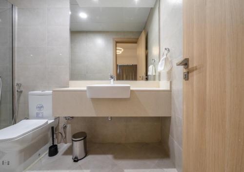 een badkamer met een wastafel, een toilet en een spiegel bij 151 Residence Jumeirah Gardens in Dubai