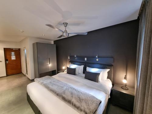 um quarto com uma cama grande e uma parede preta em Atlantic Affair Boutique Hotel em Cidade do Cabo