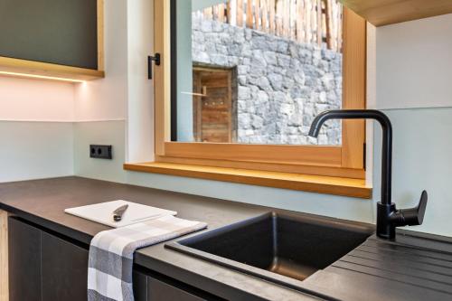 eine Küchentheke mit einem Waschbecken und einem Spiegel in der Unterkunft Chalet Kasch Apartment Glück in Vols am Schlern