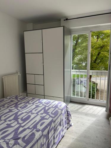 - une chambre avec un lit et une grande fenêtre dans l'établissement Spacieux Appartement avec 3 Chambres, à Évry-les-Châteaux