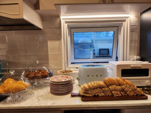 a kitchen counter with bread and plates and a window at La Campagne Villa Chiangmai in Chiang Mai