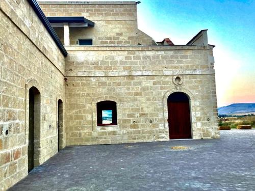 a large brick building with a red door at La Commenda di Picciano - Country House in Matera