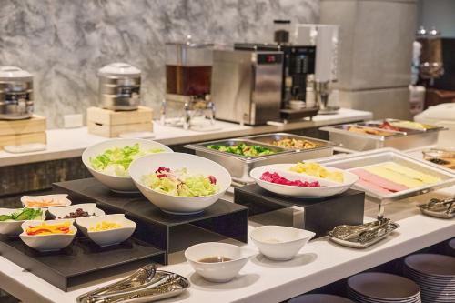 a buffet with bowls of food on a table at Orange Hotel - Linsen, Taipei in Taipei