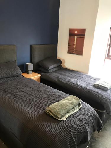 a bedroom with two beds and a chair at Prestwick Flat Central Location in Prestwick