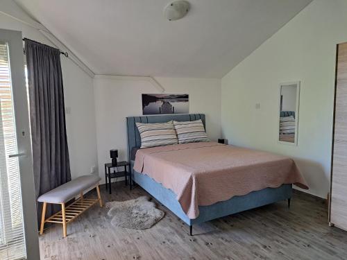 ein Schlafzimmer mit einem Bett, einem Stuhl und einem Fenster in der Unterkunft Apartmani DBS in Vir