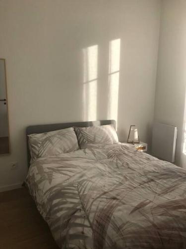 Ce lit se trouve dans une chambre dotée d'un mur blanc. dans l'établissement Central Nice 3 bed modern flat close to the beach, à Nice