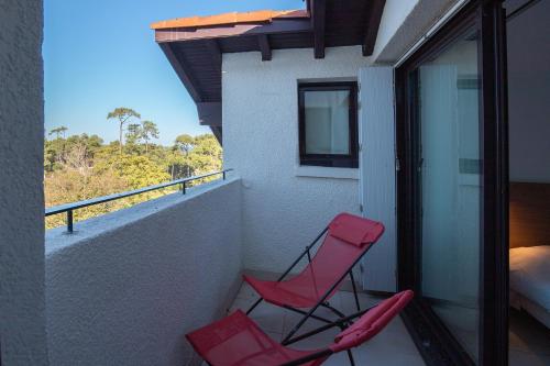 two red chairs on a balcony with a bed at VVF Résidence Anglet in Anglet