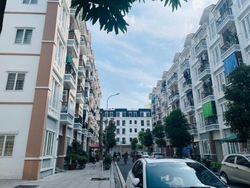 a car parked on a street with tall buildings at Basic Guest House Hải Phòng in Hai Phong