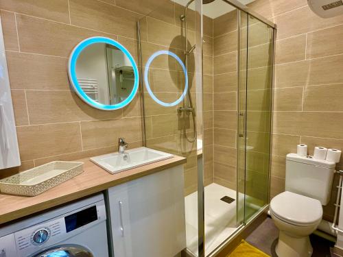 a bathroom with a toilet and a sink and a mirror at Suite Clovis - 1 in Reims