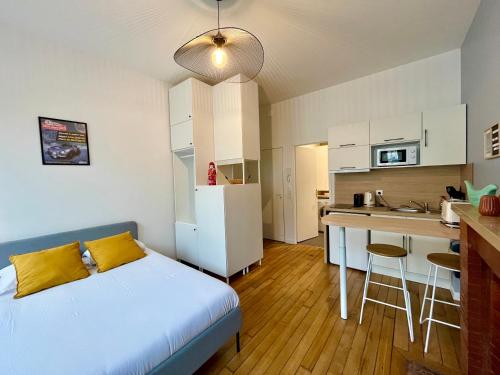 une petite chambre avec un lit et une cuisine dans l'établissement Suite Clovis - 1, à Reims