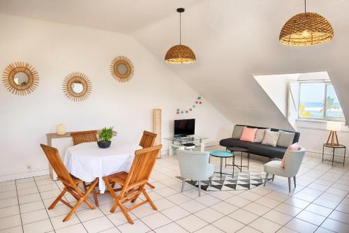 a living room with a table and chairs and a couch at Le Bulbul - T2 à 100m de la plage - La Saline les Bains in La Saline les Bains