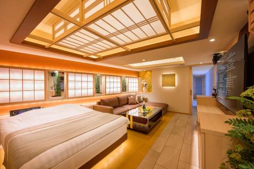 ein Schlafzimmer mit einem großen Bett und ein Wohnzimmer in der Unterkunft Hotel P'sResort Adults only 大人専用 in Tokio