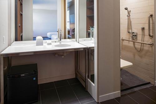 bagno con lavandino e specchio di Aloft Santa Clara - San Jose North a San Jose